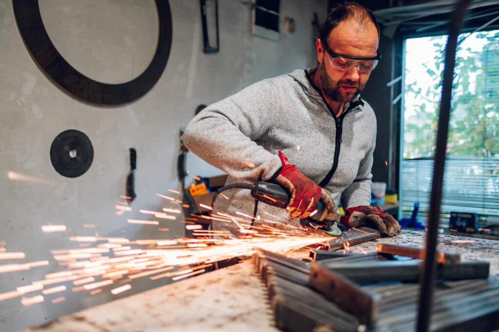 Worker in a factory grinding metal with a grinder